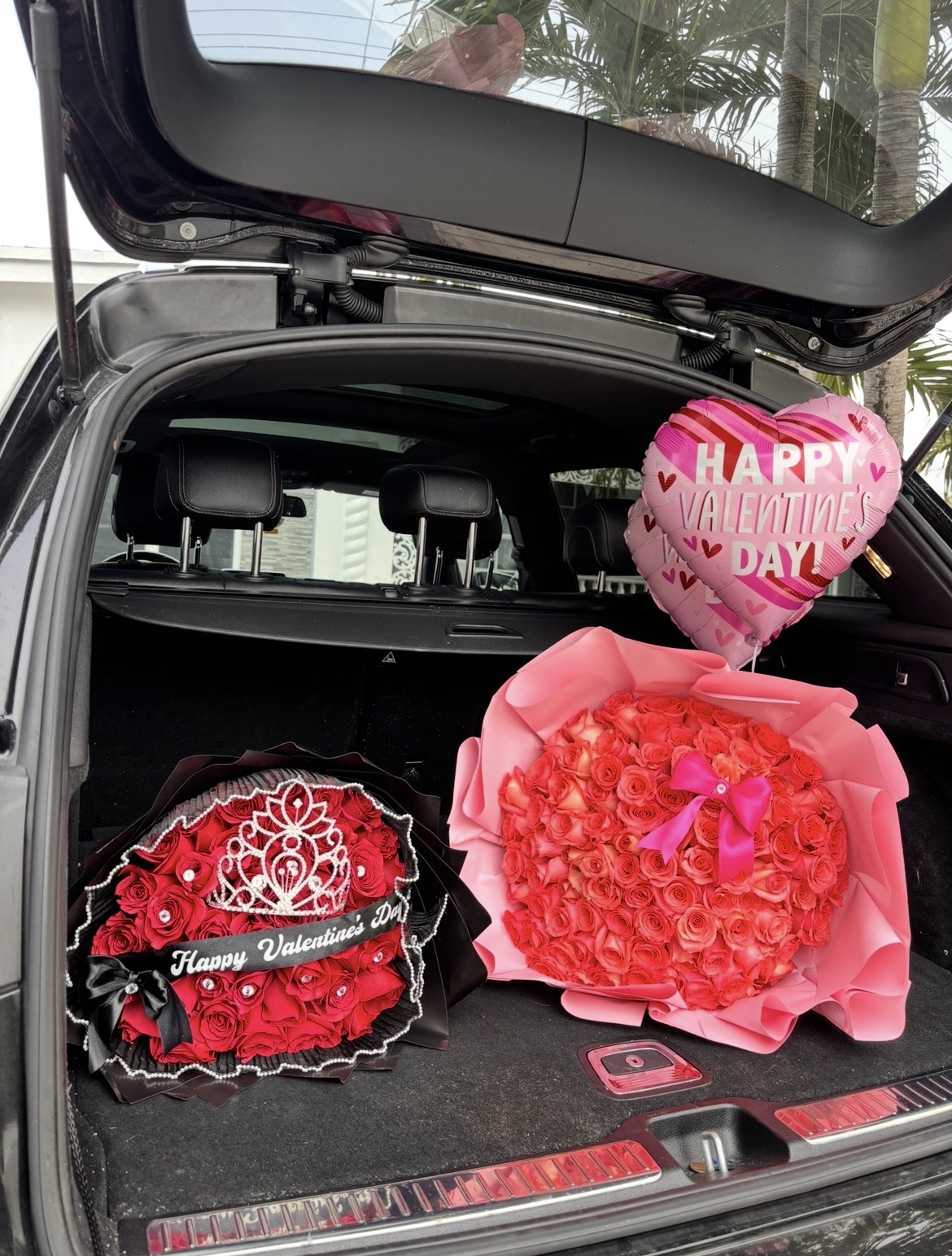 Pink peonies and roses in a modern black vase